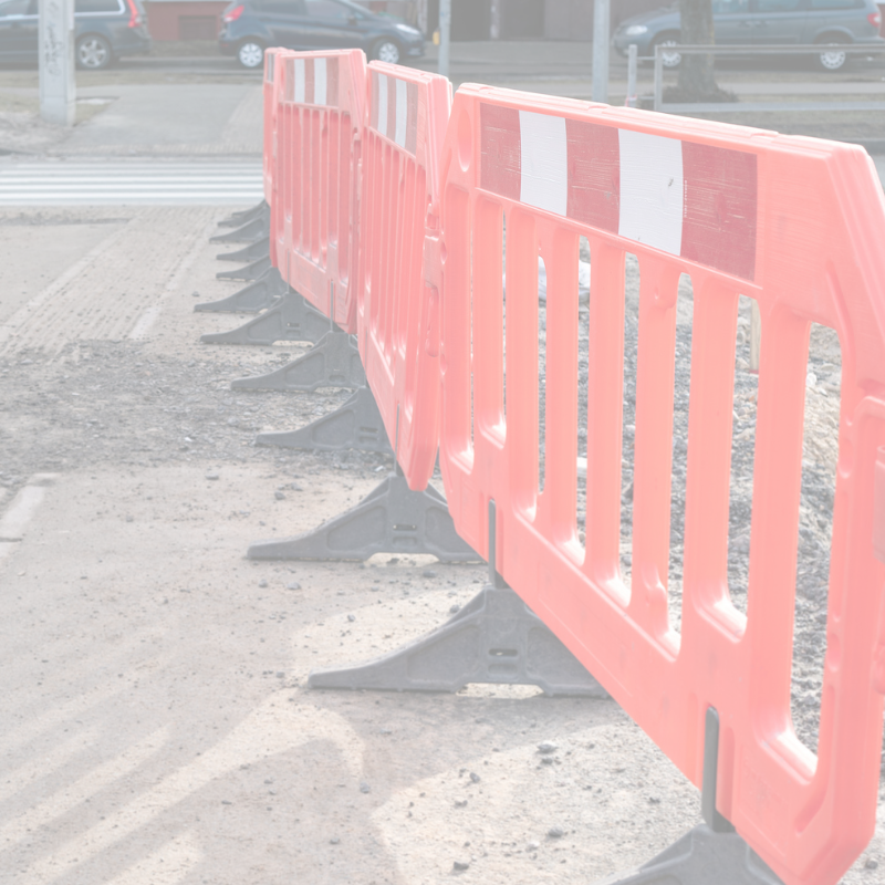 Row of red & white construction barriers on a road