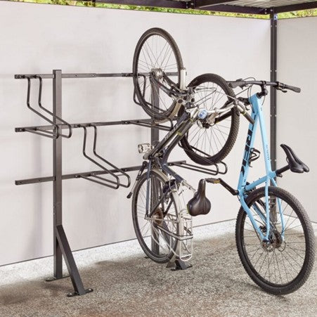 Bicycle rack holding two bicycles against a white wall.